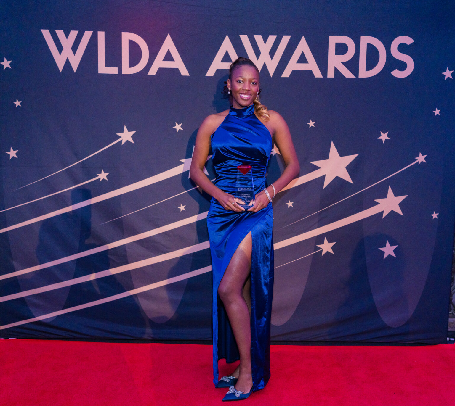 An honoree in a sapphire gown on the red carpet